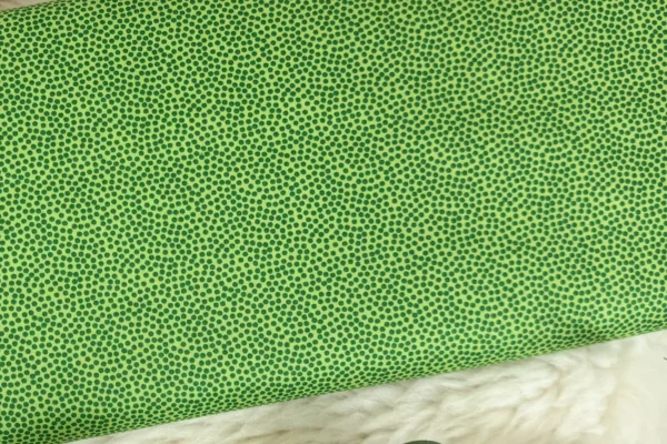 Baumwollstoff mit bunten, unregelmäßigen Punkten in apfelgrün